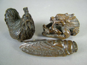 Appraisal: Three Japanese wooden netsuke carved as a locust a dragon