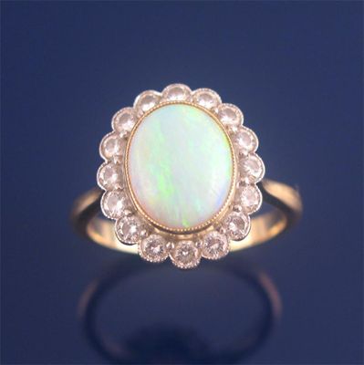 Appraisal: An opal and diamond cluster ring the oval shaped opal