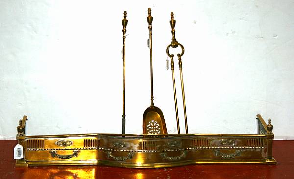 Appraisal: An English brass fire fender and a three piece set