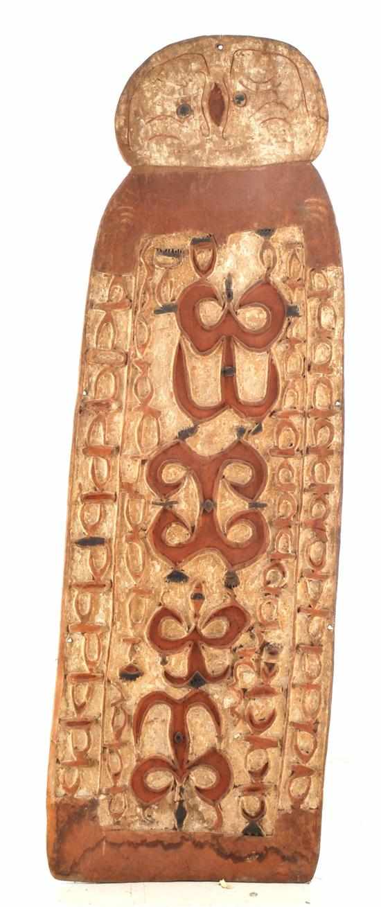 Appraisal: LARGE ASMAT WAR SHIELD CURVILINEAR INCISED DESIGN and remnant ochres