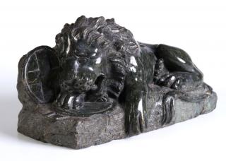 Appraisal: The carved recumbent lion with head resting on a shield