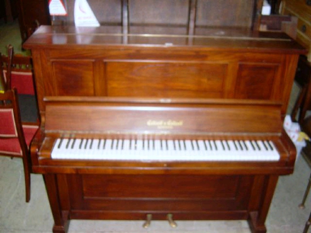 Appraisal: A walnut cased iron framed over strung upright piano by