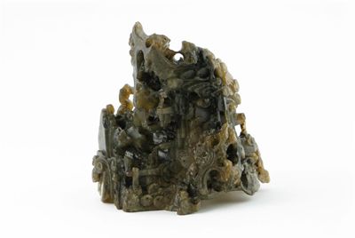 Appraisal: A Chinese soapstone carving of a rocky outcrop with pine