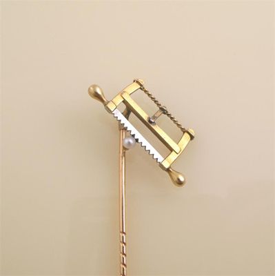 Appraisal: A gold stick pin with a cross cut Saw in