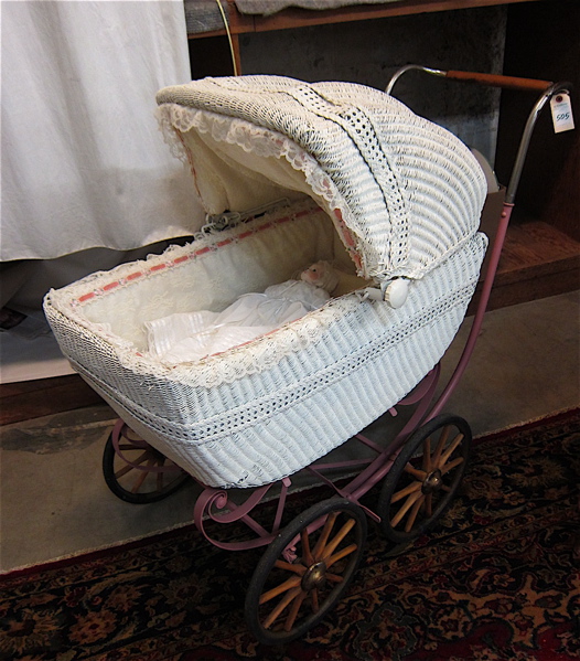 Appraisal: WICKER BABY CARRIAGE WITH DOLL American c s featuring a