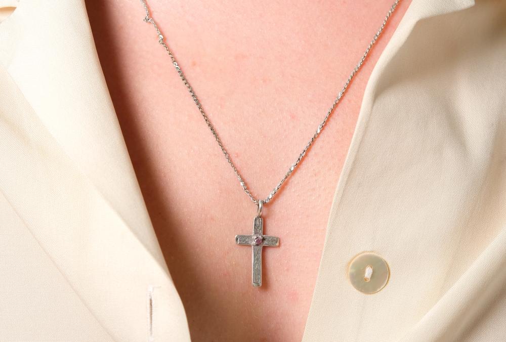 Appraisal: Sterling silver necklace hung with a sterling cross shaped pendant