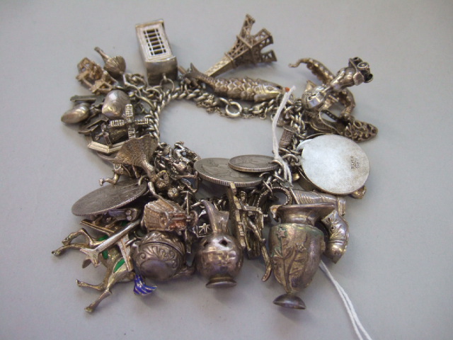 Appraisal: A silver charm bracelet fitted with a variety of charms