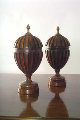 Appraisal: A pair of turned mahogany and ribbed covered urns with