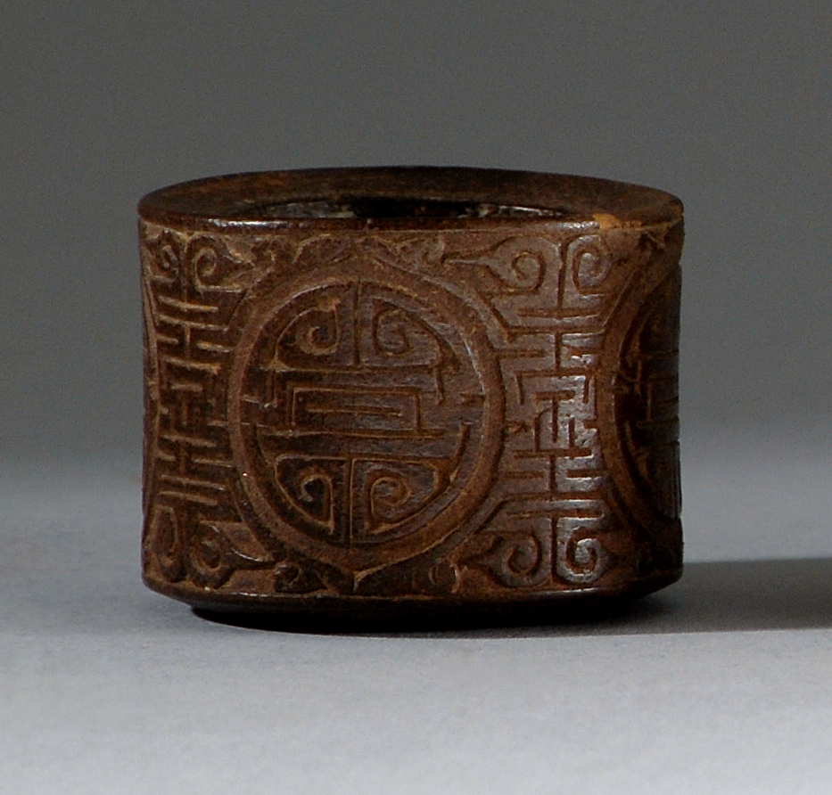 Appraisal: COCONUT SHELL ARCHER'S RING th CenturyIn cylinder form with allover