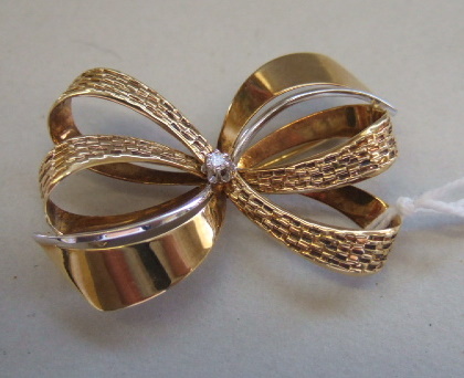 Appraisal: A gold and diamond set brooch designed as a ribbon