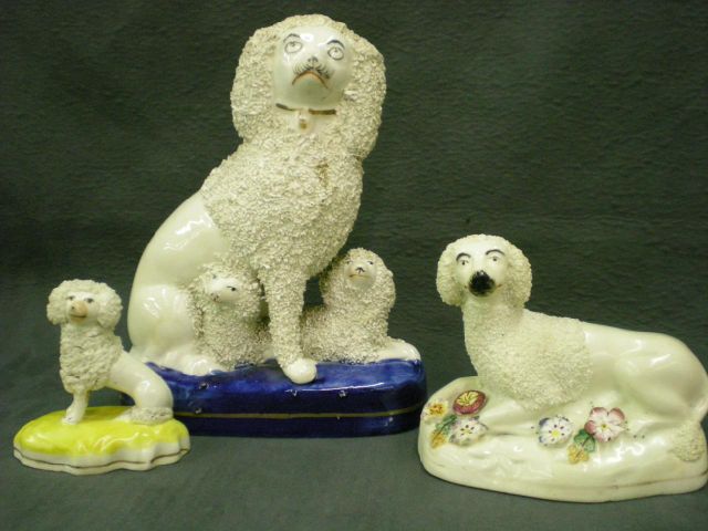 Appraisal: Three Staffordshire poodle figurines including white poodle in bed of