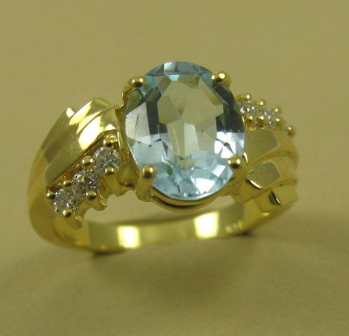 Appraisal: BLUE TOPAZ AND DIAMOND RING k yellow gold and centering