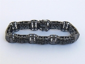 Appraisal: A patinated silver and black stone bracelet the thick rectangular