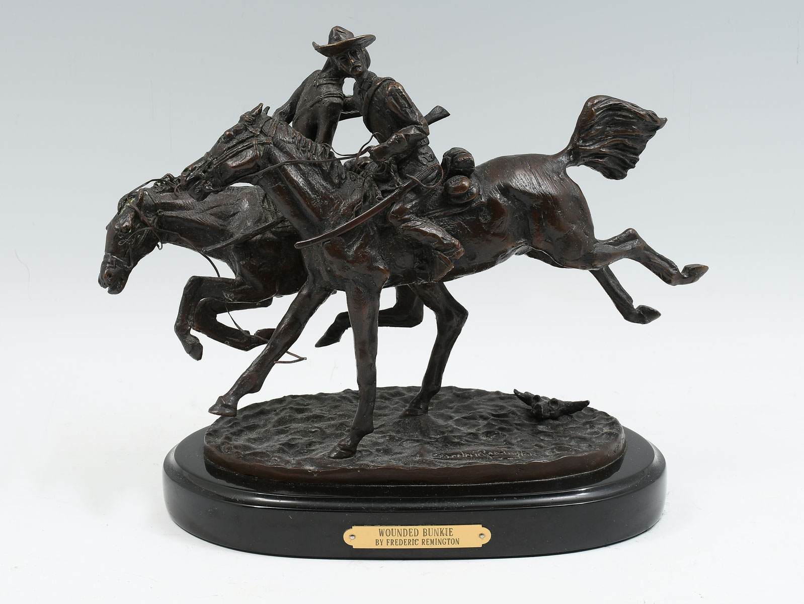 Appraisal: AFTER FREDERIC REMINGTON ''THE WOUNDED BUNKIE'' BRONZE Bronze sculpture on