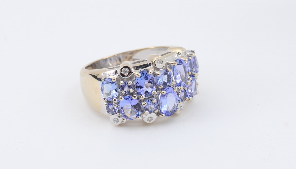 Appraisal: TANZANITE WIDE BAND RING Oval and round cut tanzanite totaling