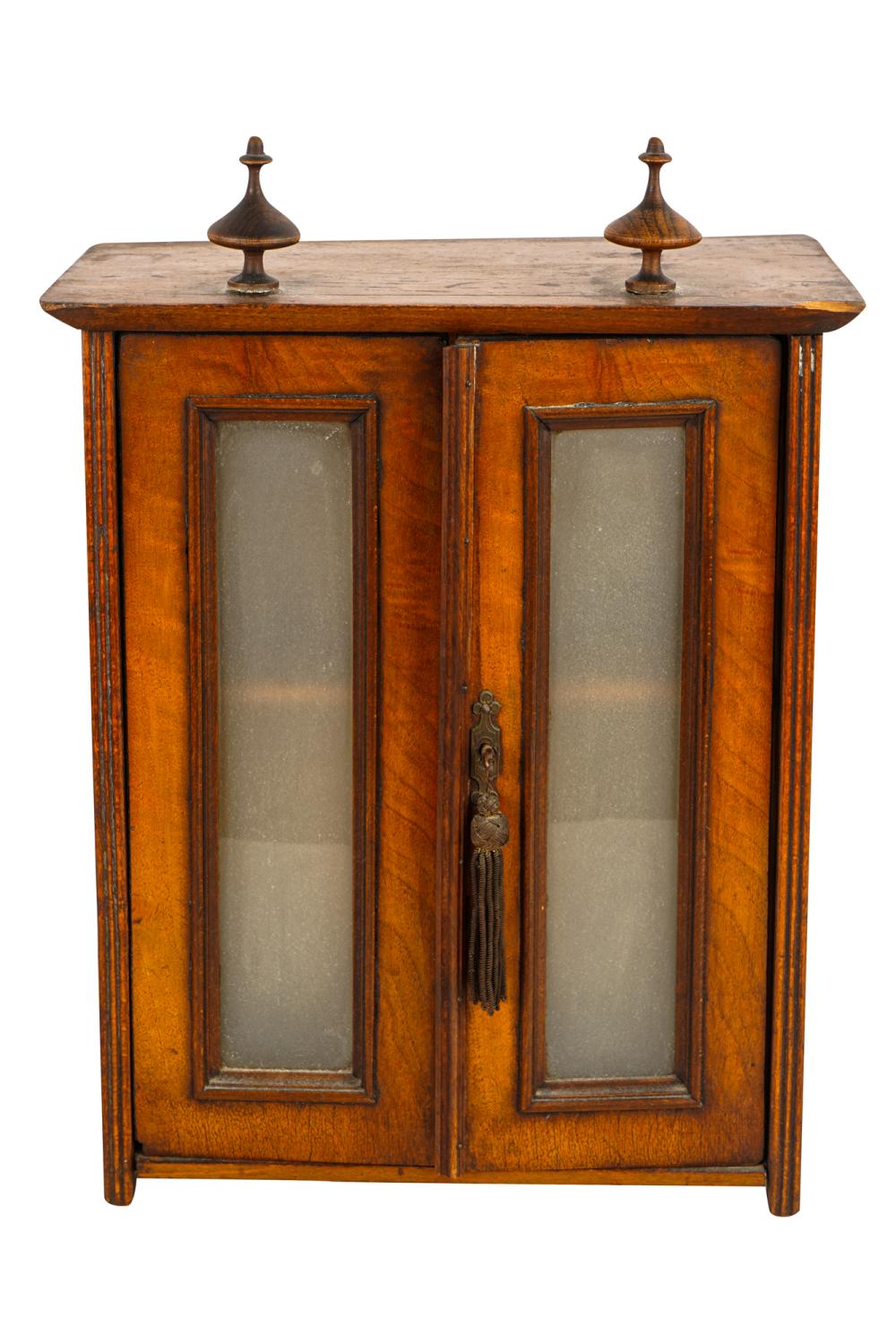 Appraisal: DIMINUTIVE MAHOGANY CABINETwith two removable finials over two glazed doors