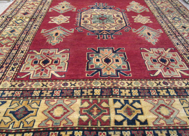 Appraisal: HAND KNOTTED ORIENTAL AREA RUG Caucasian Kazak design featuring geometric