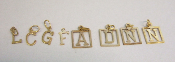 Appraisal: Sixteen gold small capital letter charms