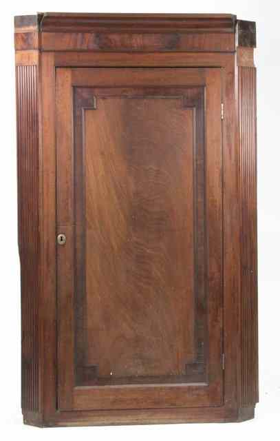 Appraisal: A George III mahogany corner cupboard the panel door enclosing