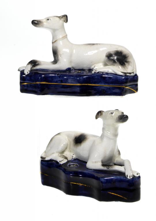 Appraisal: A PAIR OF STAFFORDSHIRE MODELS OF RECUMBENT HOUNDS sponged with