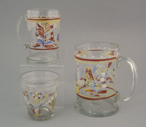 Appraisal: Two colorless glass mugs mid th c with enamel decoration