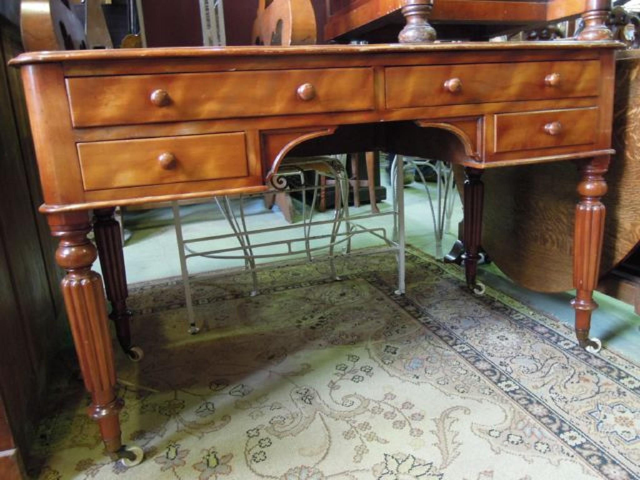 Appraisal: A Victorian satin birch kneehole writing table with inset leatherette