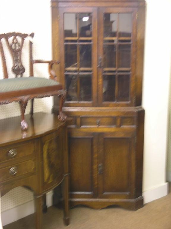 Appraisal: A solid dark oak corner cabinet floor standing the upper