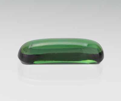 Appraisal: An Unmounted Green Tourmaline Cabochon Elongated cabochon cut green tourmaline