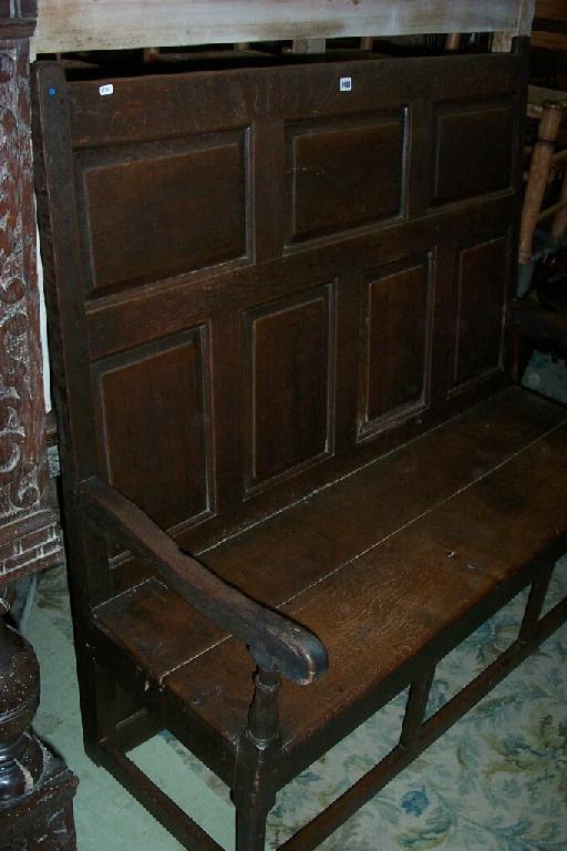 Appraisal: An th century oak settle with fielded panelled back scrolled