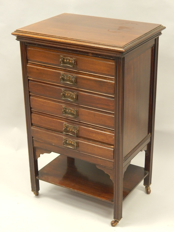 Appraisal: An Edwardian mahogany music stand with six drawers and oxidised