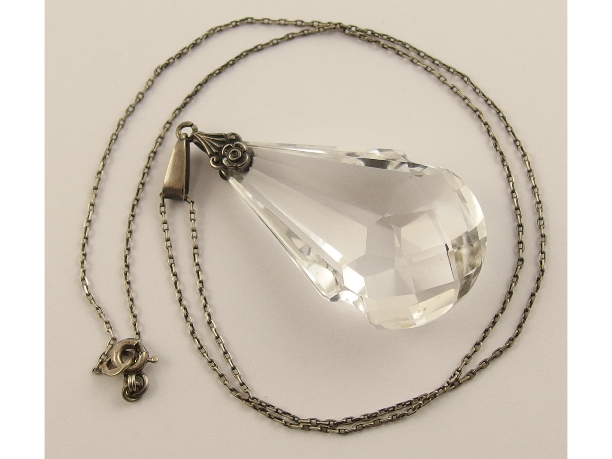 Appraisal: An Art Deco rock crystal pendanthand carved faceted lobed form