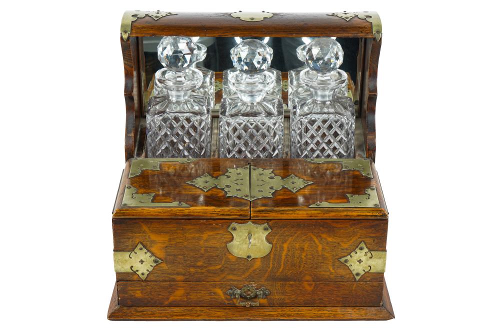 Appraisal: BRASS-MOUNTED OAK TANTALUSwith three cut-glass decanters locking compartment inches wide