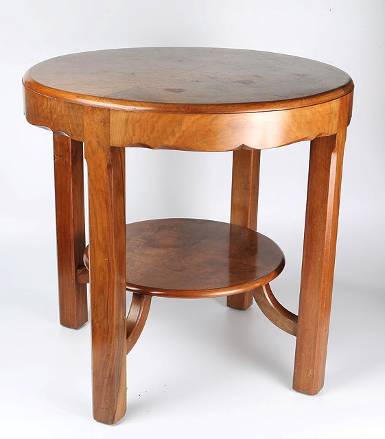 Appraisal: Cotswold SchoolTwo-tier occasional tablewalnut with shaped apron and chamfered legs