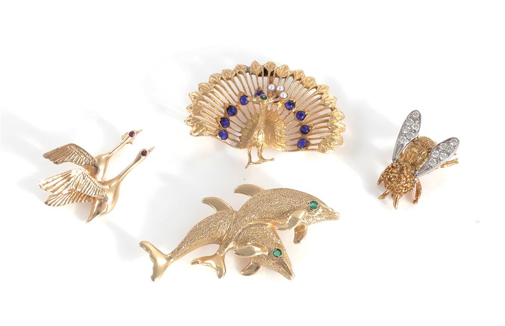 Appraisal: Gemstone and gold brooches emerald eye K dolphin L diamond-set