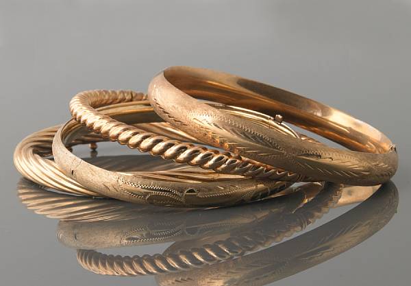 Appraisal: A collection of four gold bangles and one bracelet of