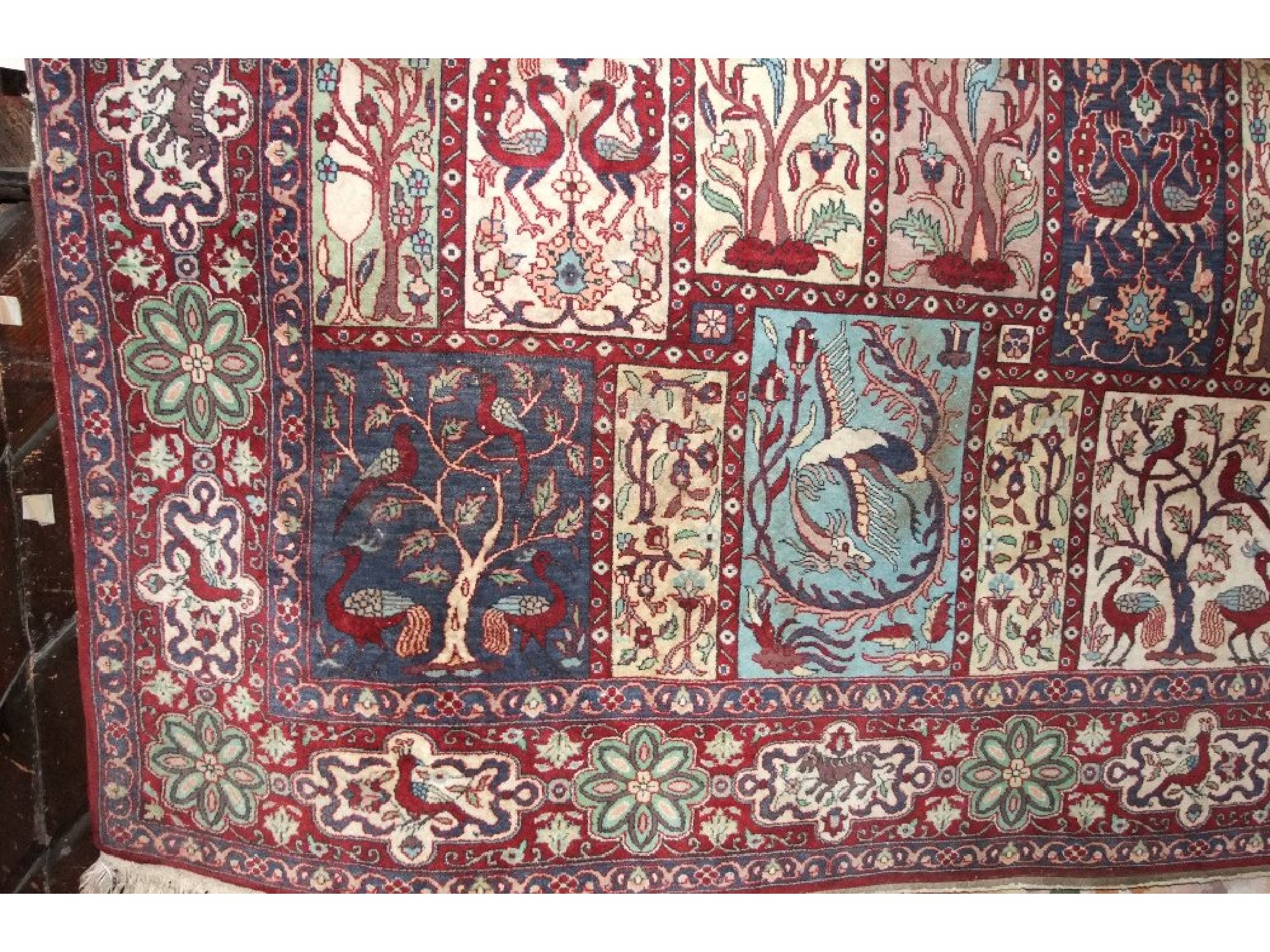 Appraisal: A Persian style wool rug with multi-panelled detail showing birds