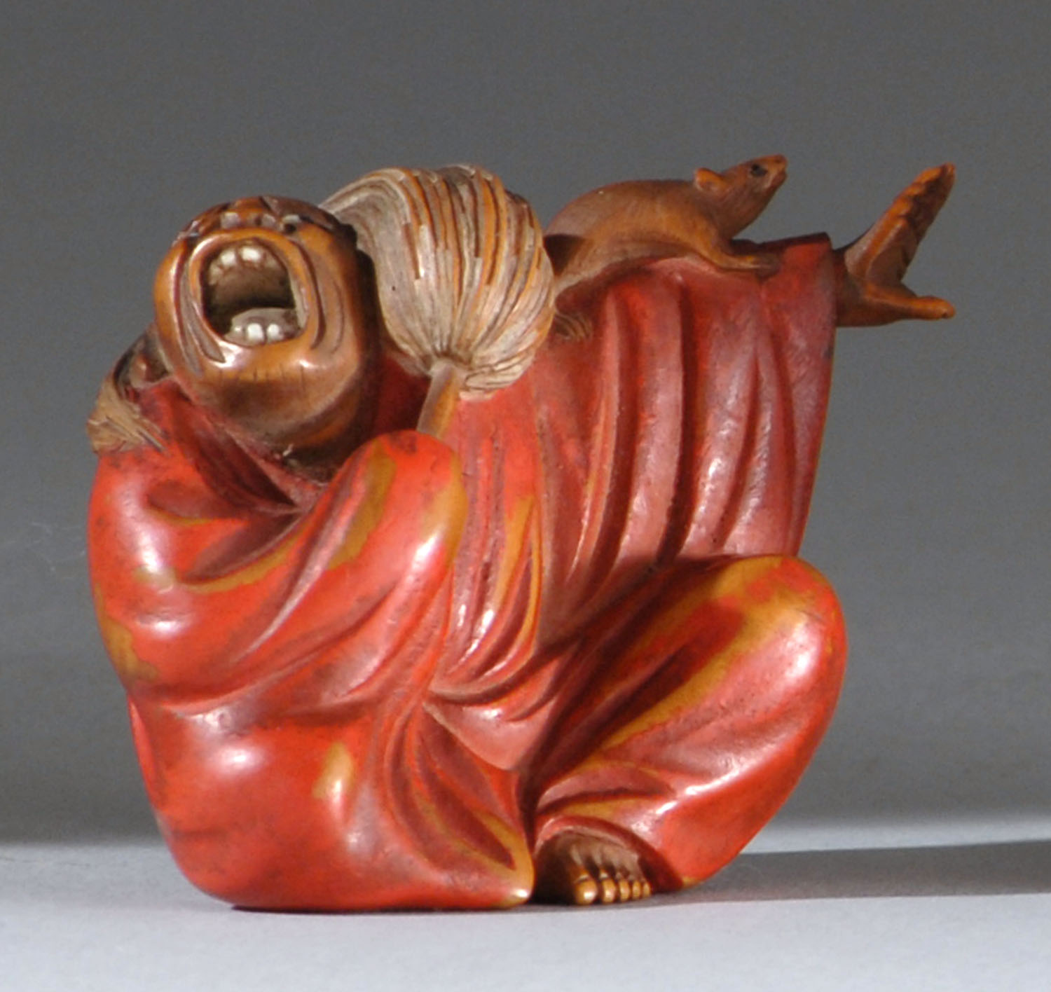 Appraisal: POLYCHROME WOOD NETSUKE Late th CenturyDepicting Daruma holding a fly