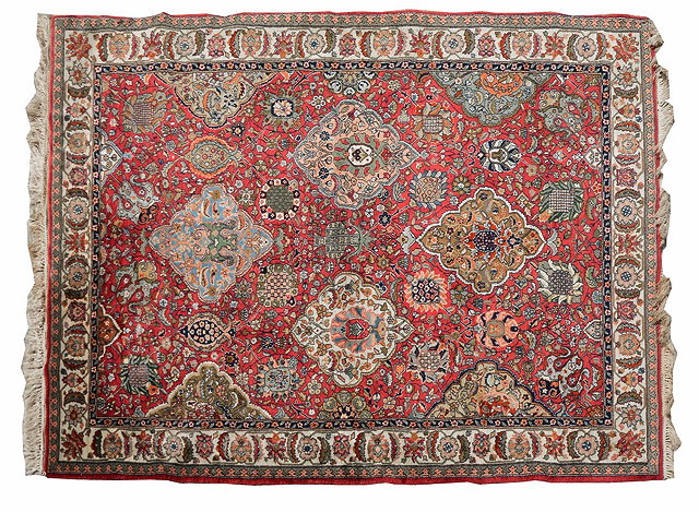 Appraisal: AN INDO-PERSIAN BRICK RED GROUND RUG with a continuing pattern