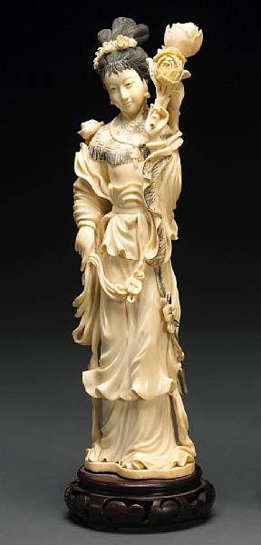 Appraisal: A tinted ivory beauty th Century Shown holding a flowering