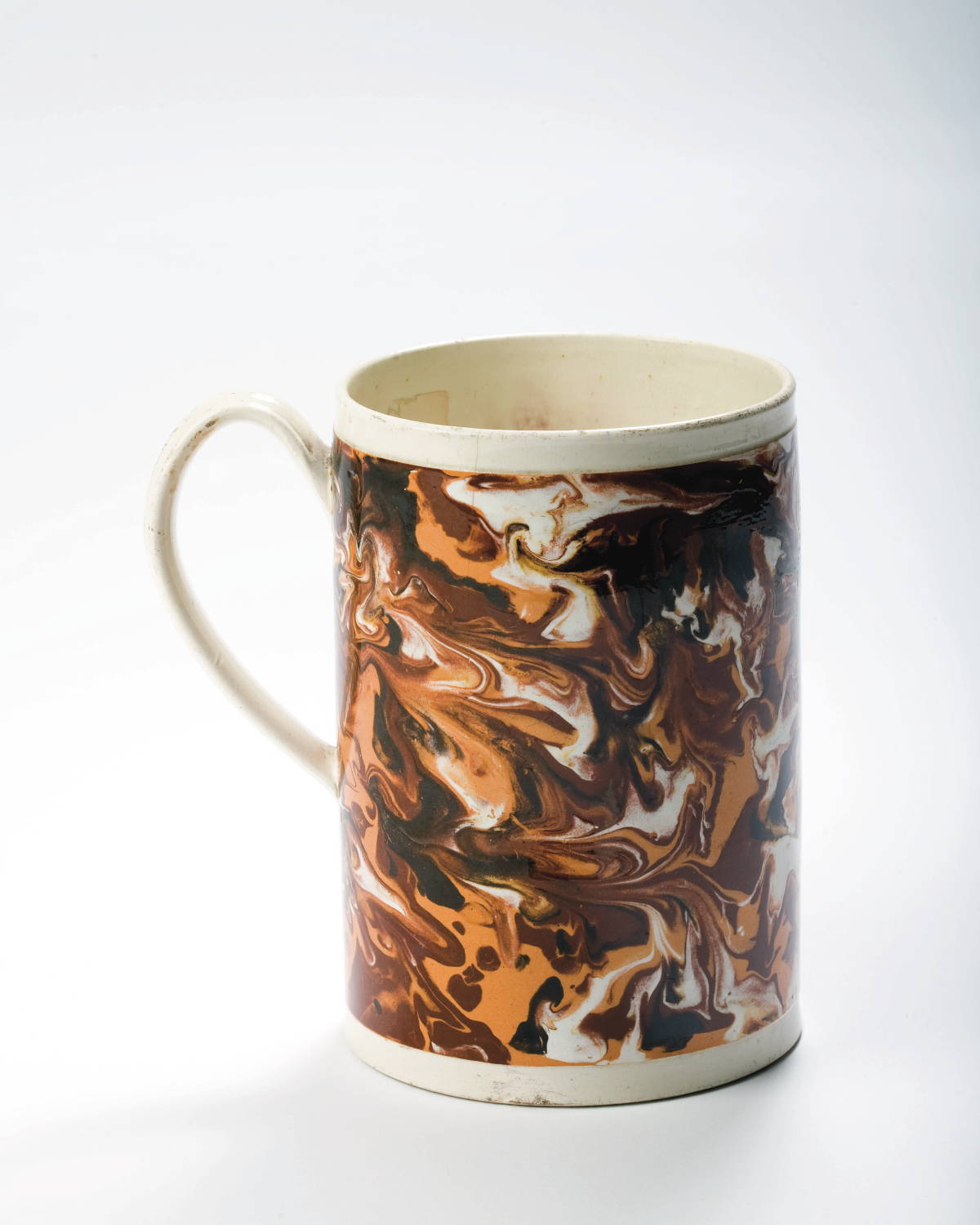 Appraisal: BRITISH CREAMWARE MOCHAWARE QUART MUG CIRCA Slip-marbled in black rust