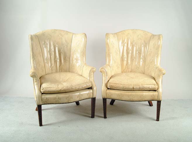 Appraisal: PAIR OF LEATHER EMBOSSED UPHOLSTERED WING CHAIRS Ivory leather upholstery