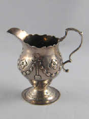 Appraisal: A Georgian silver cream jug with embossed swags on spread