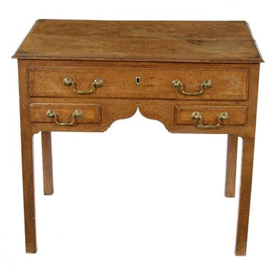 Appraisal: A George III oak lowboy the twin plank moulded edge