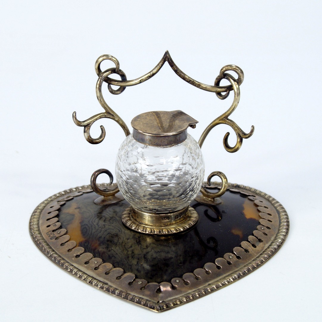 Appraisal: An Edwardian ladies heart shaped tortoiseshell and silver desk stand