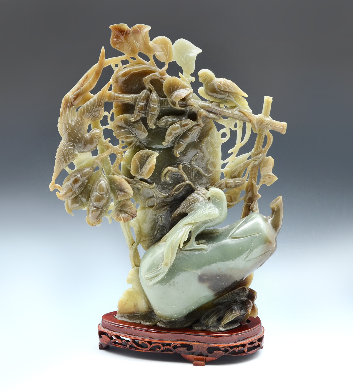 Appraisal: CARVED EGGPLANT JADE SCULPTURE WITH BIRD AND PEAS Carved pierced