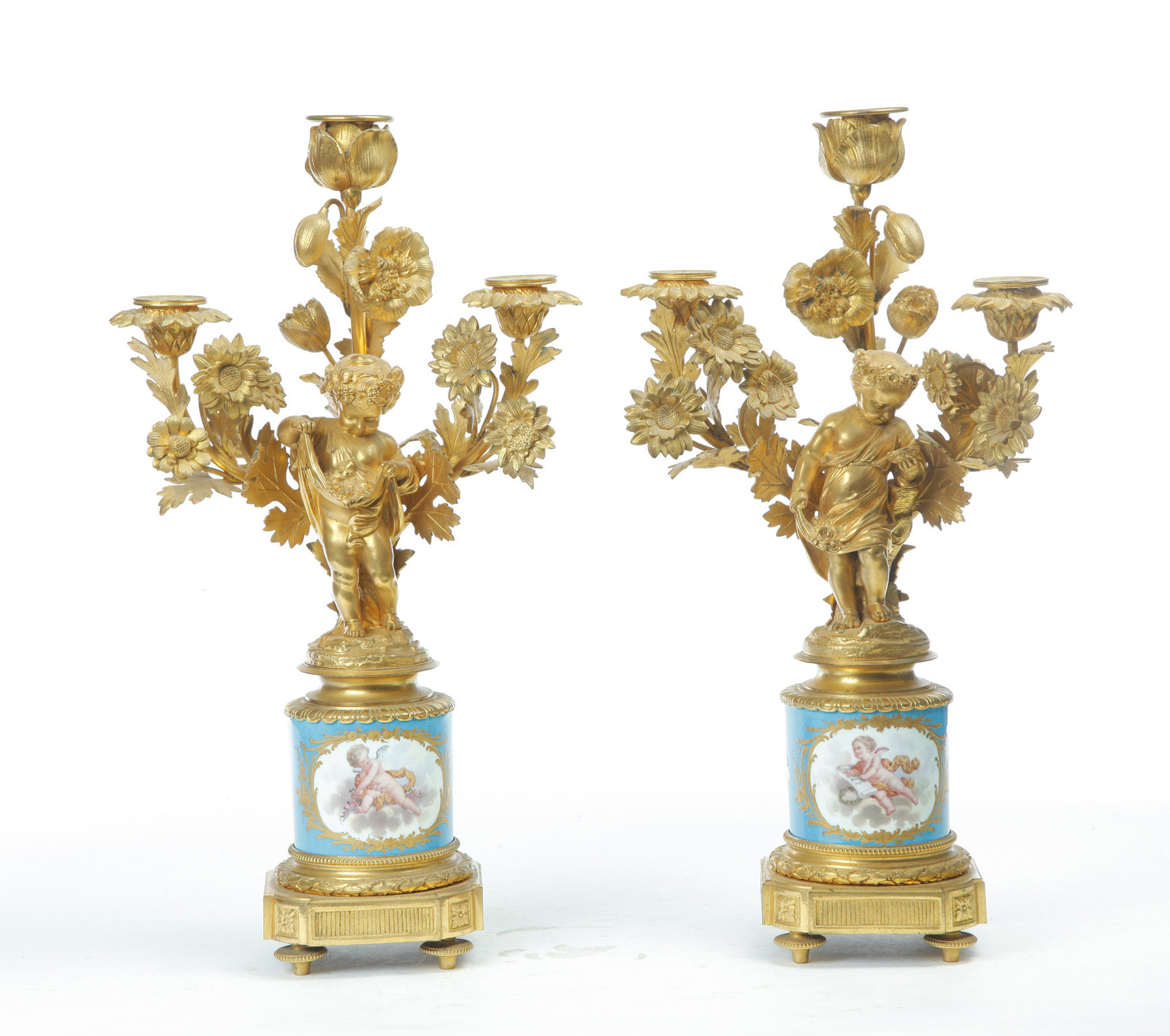 Appraisal: PAIR OF FIGURAL THREE-BRANCH CANDELABRAS WITH PORCELAIN INSERTS France nd