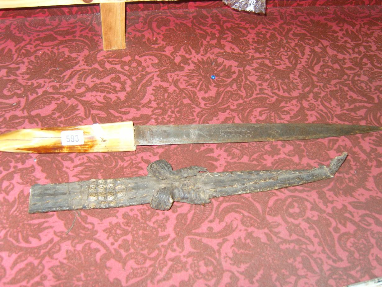 Appraisal: An ethnic dagger with tusk handle engraved blade and Cayman