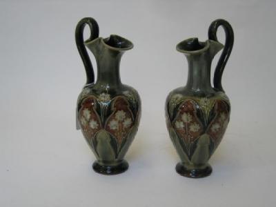 Appraisal: A PAIR OF ROYAL DOULTON STONEWARE EWERS by Eliza Simmance