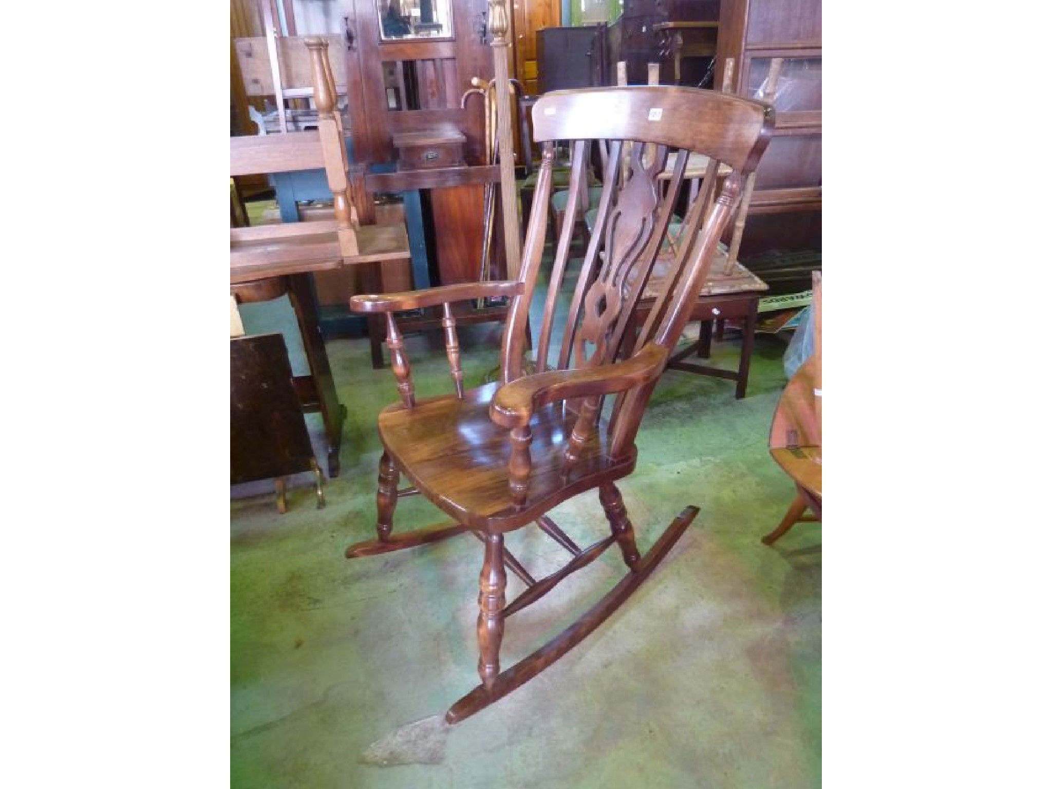 Appraisal: A Windsor lath back rocking elbow chair with turned supports