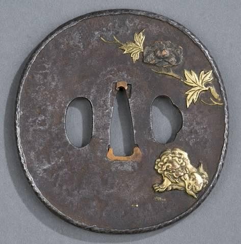 Appraisal: Iron tsuba with shi shi A Japanese iron maru gata